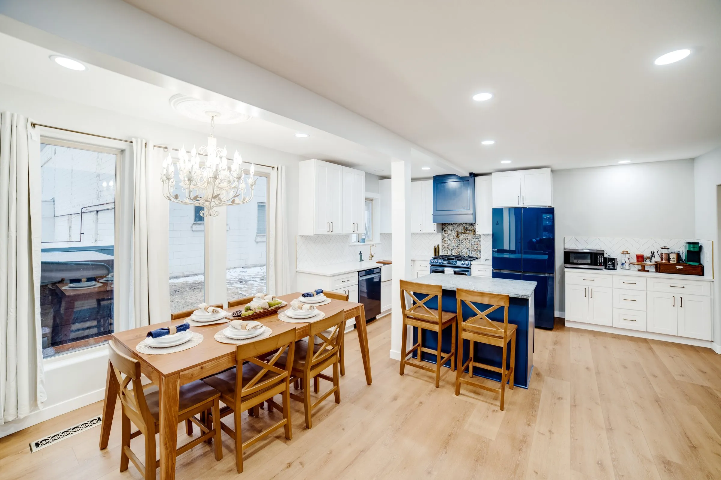 Farmhouse dining table next to the kitchen island and bar stools