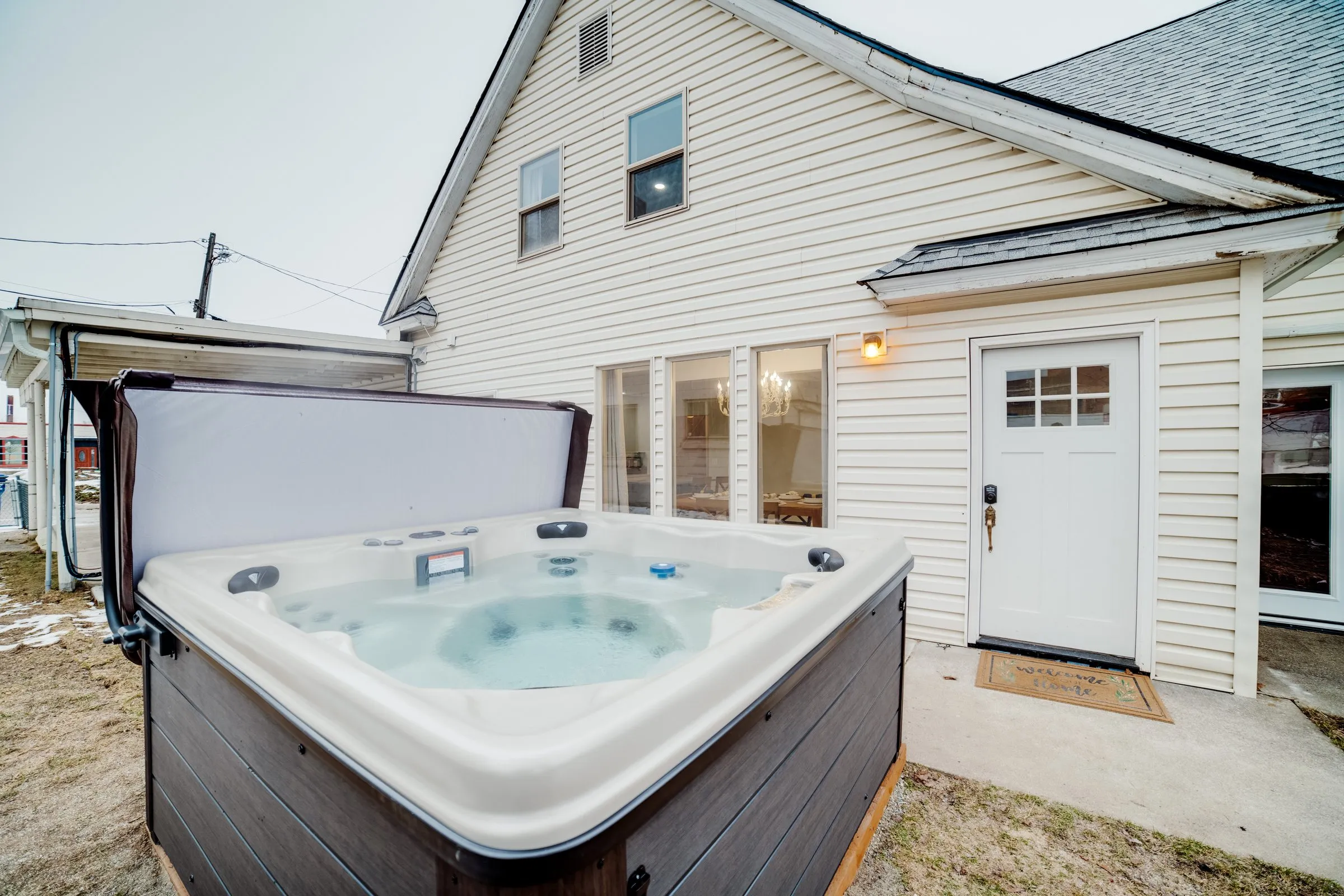 Steaming private hot tub open on the back patio of Jackass Manor